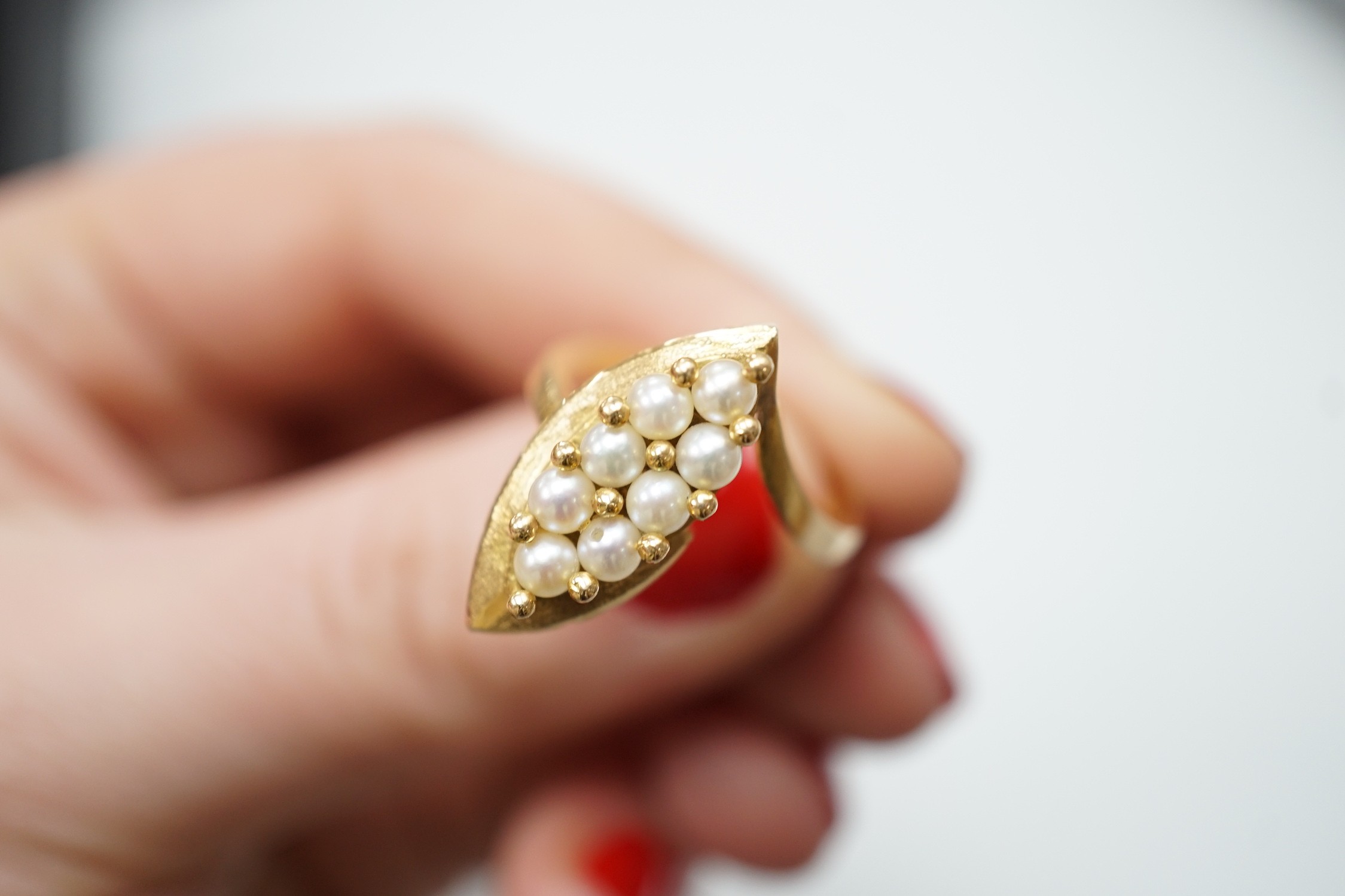 A modern continental yellow metal and seed pearl cluster set marquise shaped ring, size N